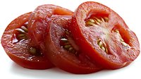Fresh ripe tomato slices with visible seeds and pulp showing natural texture and juicy flesh on white background, suitable for food photography and menu design.