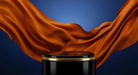 Elegant black podium with gold rim surrounded by flowing orange silk fabric against deep blue background for luxury product display and premium branding presentations.