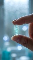 Hand holding transparent capsule with DNA double helix structure inside against blurred laboratory background with bokeh lights for genetic research concepts.