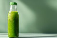 Fresh green smoothie in glass bottle with cap on wooden surface against blurred green background for healthy lifestyle and nutrition concepts.