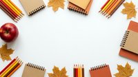 Autumn school supplies frame with colorful pencils, notebooks and maple leaves on white background. Back to school concept for educational design.