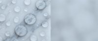 Water droplets on a light gray waterproof fabric surface, showing hydrophobic effect with blurred background for copy space.
