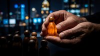 Businessman holding glowing amber stone with cityscape background, representing leadership, success, and business growth opportunities.