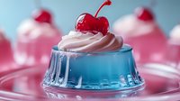 Blue gelatin dessert topped with pink whipped cream and red cherry on glass plate. Sweet treat for parties, celebrations, and dessert menus.
