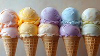 Colorful ice cream scoops in waffle cones arranged in rows showing various flavors including vanilla, strawberry, and mint on neutral background.