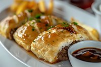 Juicy beef wrapped in flaky golden phyllo pastry, garnished with fresh herbs and served with rich dipping sauce. Close-up view shows delicate layers and glazed finish.