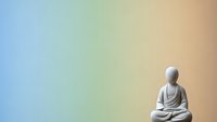 Peaceful Buddha statue in meditation pose against soft gradient background for mindfulness and spiritual wellness designs.