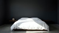 Unmade bed with white rumpled bedding and pillows on wooden platform against dark gray wall, minimal bedroom interior design.