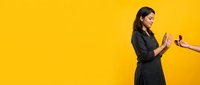 Young professional businesswoman in dark suit using smartphone against bright yellow background for corporate communication and technology concepts.