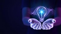 Glowing lightbulb with brain inside floating above open hands on dark background representing innovation, creativity and bright ideas for business solutions.