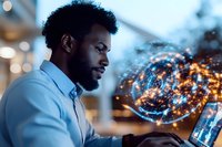 Young African American businessman analyzing digital data network with glowing connections on laptop in modern office environment for technology presentations.