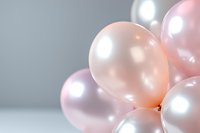 Soft pink and white pearl balloons create dreamy party atmosphere against light background, close-up view with selective focus and copy space.
