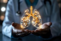 Glowing golden lungs held in medical professional's hands against dark background, illuminated with sparkles suggesting healing and respiratory health.