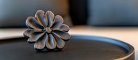 Decorative wooden flower carving on dark surface with soft natural lighting and shallow depth of field, handcrafted artisanal detail in rustic style.
