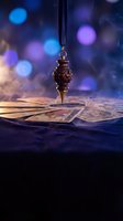 Ornate bronze pendulum hanging over vintage tarot cards with mystical bokeh lights creating magical atmosphere for fortune telling and divination practices.