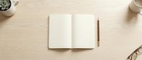 Open notebook with blank pages on wooden desk with pen, eyeglasses, coffee cup and plant for writing, planning, journaling and creative work projects.