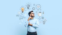 Young Asian businessman in glasses thinking with illustrated creative ideas, innovation symbols, and lightbulbs floating around head on light blue background.