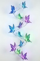 Colorful butterflies in spiral formation with glowing light effects on white background. Decorative elements for spring design projects and nature themes.