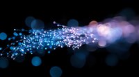 Magical glowing particles flow with blue and pink bokeh lights on black background, creating ethereal motion effect for abstract designs and backgrounds.