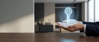 Businessman holding glowing digital key hologram above palm in modern office interior representing security access technology and data protection solutions.