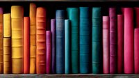 Colorful vintage books arranged in rainbow order on wooden shelf, spines showing vibrant gradient from yellow through blue to pink, creating artistic library display.