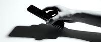 Hand holding smartphone with shadow on white background, isolated for app design, web mockup, technology marketing, and digital communication concepts.