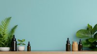 Green ferns and tropical plants in white pots with essential oil dark bottles on wooden shelf against mint wall, modern minimalist home decor styling.