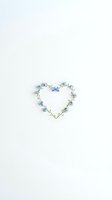 Heart-shaped floral arrangement made from delicate blue forget-me-not flowers and green stems on clean white background for romantic design projects.
