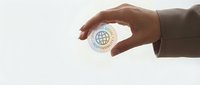 Professional hands holding white business card with global network icon representing international connectivity and corporate communication solutions.