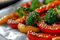 Roasted bell peppers and broccoli florets with sesame seeds on white plate, healthy vegetable side dish for cooking and nutrition content.