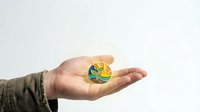 Hand holding golden cryptocurrency coin with green leaf symbol representing eco-friendly digital currency and sustainable blockchain technology investment.