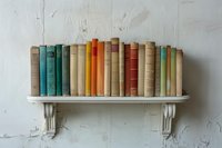 Vintage hardcover books arranged on white decorative wall shelf against textured plaster wall, showcasing multicolored spines in muted tones for home library decor.