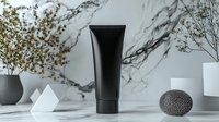 Black cosmetic tube on marble background with minimal decor elements and dried flowers. Modern luxury skincare product photography for beauty brands.