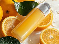 Fresh orange juice in glass bottle surrounded by sliced citrus fruits and green leaves on wet surface with water drops, natural vitamin drink.