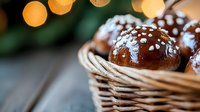 Chocolate glazed profiteroles with almond flakes in wicker basket against blurred bokeh lights background, close up view of fresh pastries.