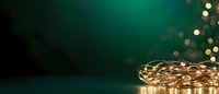 Glowing fairy lights creating magical bokeh effect against dark emerald green background, festive holiday atmosphere with copy space for text.