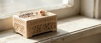 Ornate wooden jewelry box with intricate carved floral patterns sits on rustic wood surface in soft natural light for home decor and storage solutions.