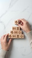Hands arranging wooden blocks with legal and justice symbols in pyramid formation on marble surface for business and law concepts.