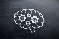 Brain with mechanical gears drawn in chalk on blackboard, representing cognitive function, mental processes, and problem-solving concepts.