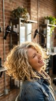 Happy blonde woman laughing in modern hair salon with brick walls and professional styling equipment creating joyful atmosphere for beauty services.