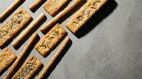Carved wooden blocks with decorative patterns arranged diagonally on neutral surface, suitable for craft, design, and artistic projects.