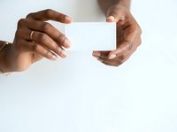 Close-up of hands holding blank white card against neutral background, ready for custom text or branding. Isolated design element for business, marketing, and promotional materials.