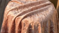 Luxurious velvet fabric draped elegantly with soft folds and rich texture, showcasing warm brown tones and plush material for interior design projects.