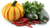 Fresh orange pumpkin with green zucchini, bright red chili peppers and parsley leaves arranged on white background, isolated healthy vegetables composition.