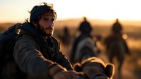 Bearded man in outdoor adventure scene with backpack gazing at sunset while others on horseback silhouetted in golden hour background. Atmospheric wilderness journey.