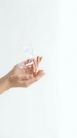 Female hands holding shattered iridescent glass fragments against white background, symbolizing innovation, creativity, and digital transformation for design and technology projects.