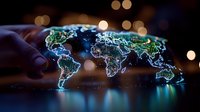 Glowing digital world map with neon blue and green illuminated continents on dark background with bokeh lights, reflecting on glossy surface.