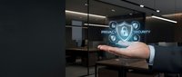 Male professional in business attire holding digital security shield with privacy icons in modern office setting, representing data protection and cybersecurity solutions.