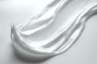 Smooth white cream texture with elegant flowing curves and soft shadows on light background, suitable for cosmetic and skincare product advertising.