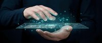 Young male professional with light skin tone holding glowing digital network interface between hands against dark background, representing technology innovation and data connectivity for business solutions.
